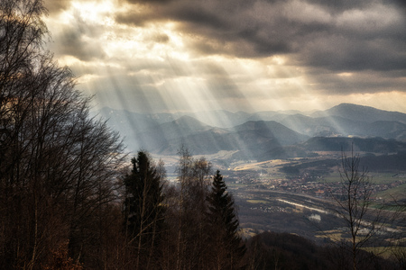 Sunlight over country. Sun rays through cloudsの写真素材