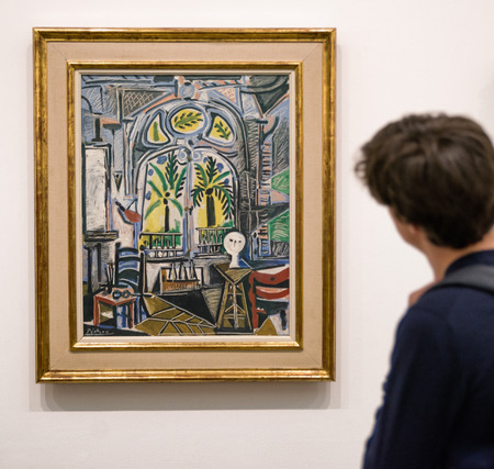 NDON, UNITED KINGDOM - MAY 12: Man looking at oil painting The Studio from Pablo Picasso at Tate modern on May 12, 2018 in LondonLOのeditorial素材