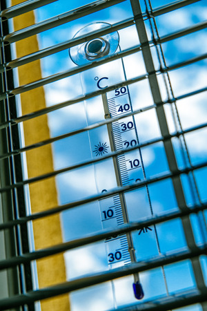 Thermometer outside the window shows a high temperature during summer heat wavesの写真素材