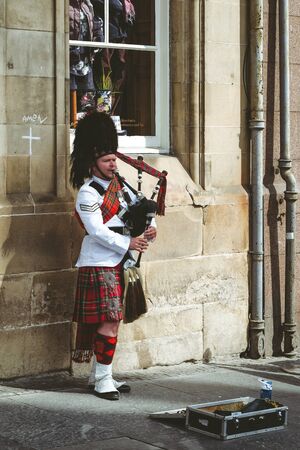 EDINBURGH, SCOTLAND - MAY 18: Scottish piper playing on bagpipe in the centre of city on May 18, 2018 in Edinburghのeditorial素材