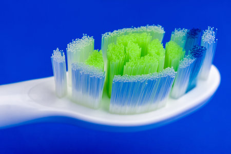 Close up view on white electric toothbrush at blue background