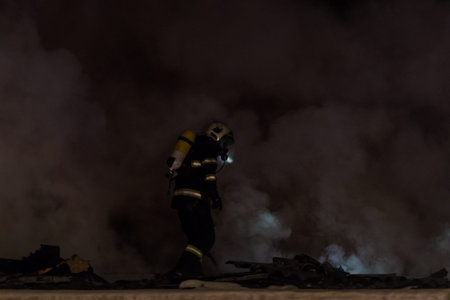 Fireman in action at night on the roof