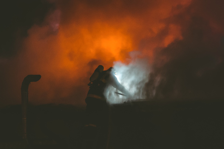 Fireman in action at night on the roofの写真素材