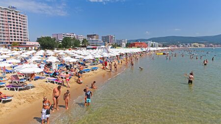 SUNNY BEACH, BULGARIA - JULY 8: Loungers under sunshades full of people and sandy beach at Sunny beach on July 8, 2013 in Sunny Beachのeditorial素材