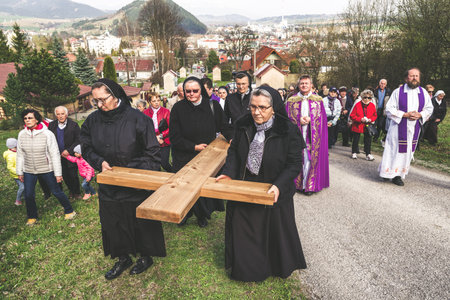 RUZOMBEROK, SLOVAKIA - APRIL 14: Nuns with cross at calvary. The Way of the cross during easter on...