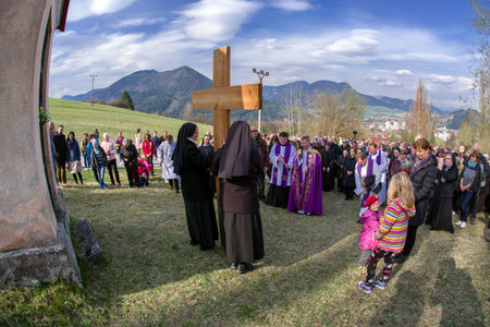 RUZOMBEROK, SLOVAKIA - APRIL 14: Nuns with cross at calvary. The Way of the cross during easter on...