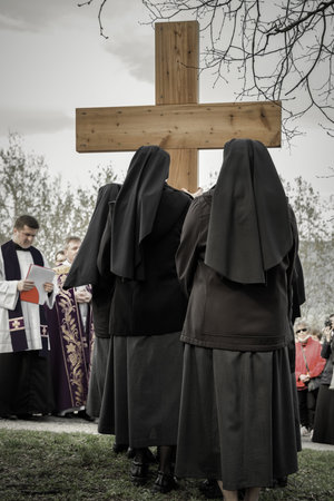 RUZOMBEROK, SLOVAKIA - APRIL 14: Nuns with cross at calvary. The Way of the cross during easter on...