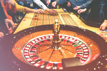Gambling people in casino. Roulette table and players