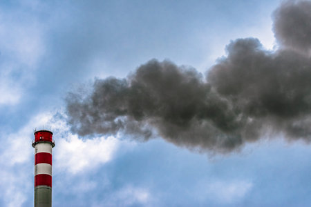 Dark smoke from chimne and blue sky