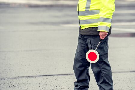 Cop in reflective vest with stop sign. Police road patrol.の写真素材