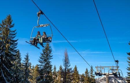 DEMANOVSKA DOLINA, SLOVAKIA - FEBRUARY 8: Skiers sitting on ski lift chair in resort Jasna in Low Tatras mountains on February 8, 2020 in Demanovska Dolinaのeditorial素材
