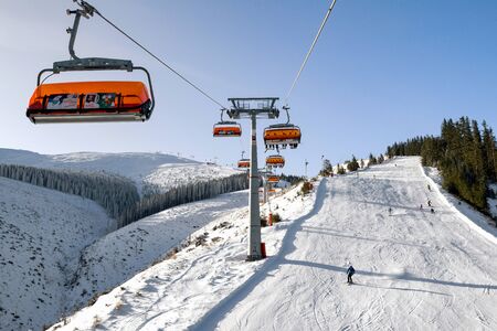 DEMANOVSKA DOLINA, SLOVAKIA - FEBRUARY 8: Skiers on slope from ski lift chair in resort Jasna on February 8, 2020 in Demanovska Dolinaのeditorial素材