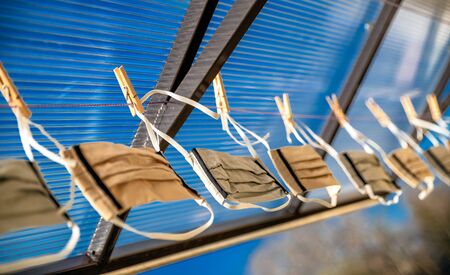 Many protective face masks hanging on a clotheslineの写真素材