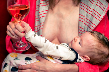 Breastfeeding baby and bad alcoholic mother with glass of wine