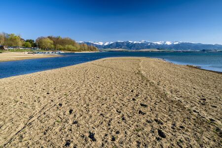 Dry soil and water reservoir Liptovska Mara, Slovakia. Low Tatras mountains at backgroundの写真素材
