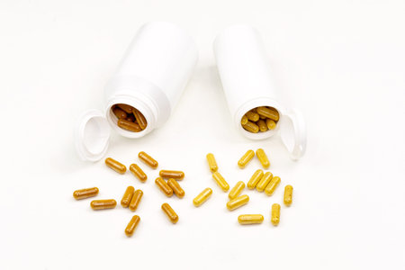 Plastic tubes full of vitamins in pills on white background