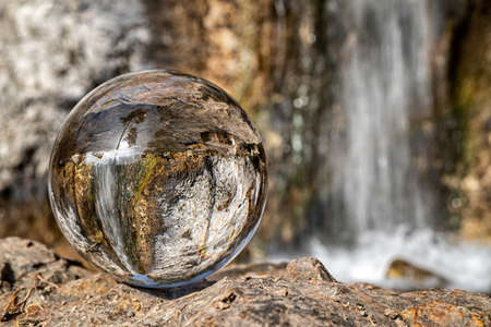 Reflection of waterfall in crystal lens ball.の写真素材