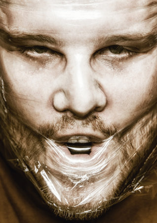 Low key portrait of evil, devil man with face in plastic wrap and psycho view