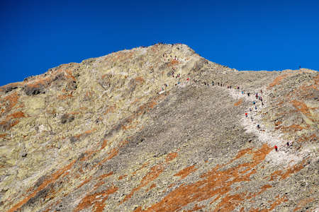 Many hikers walking on mountain trail on peak Krivan in High Tatras mountains at Slovakia.の写真素材