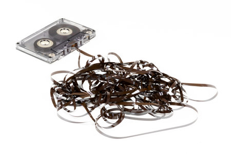 Old audio cassette with loose tape on white backgroundの写真素材