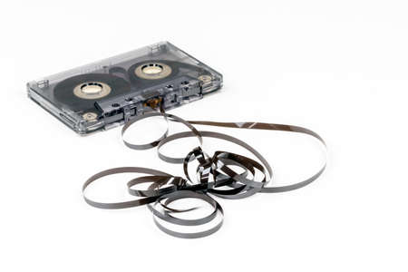 Old audio cassette with loose tape on white backgroundの写真素材