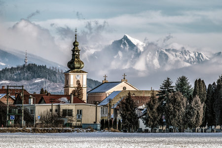 LISKOVA, SLOVAKIA - DECEMBER 12, 2021: Tower of church in village Liskova. Peak Krivan in High Tatras mountains at backgroundのeditorial素材