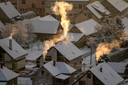 Smoking chimneys from houses during cold winter morning.の写真素材