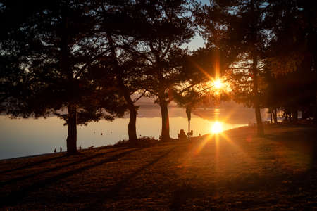 Reflection of sun on water surface. Golden hour and sunset on lake.の写真素材