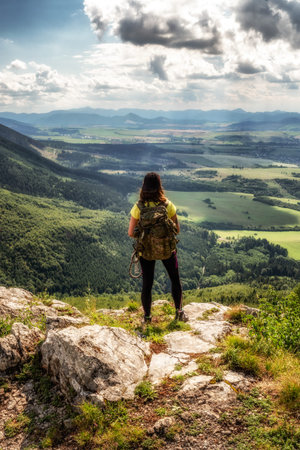 Hiking girl with backpack looking on beautiful summer mountain landscape from hill Cipcie in...