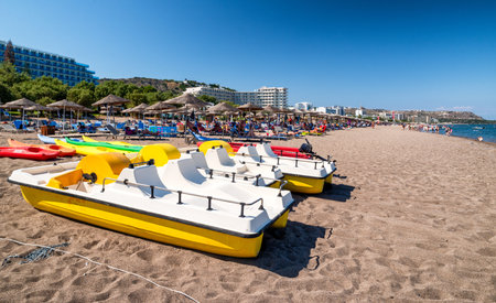 FALIRAKI, GREECE - JUN 29, 2022: Paddle boats on sandy beach in seaside resort Faliraki in Rhodes islandのeditorial素材