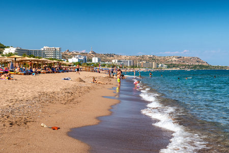 FALIRAKI, GREECE - JUN 29, 2022: People relaxing on sandy beach at resort Faliraki in Rhodes islandのeditorial素材