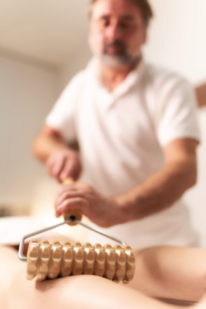 Madero therapy legs thigh muscle massage with wooden rolling pin. Spa procedure concept