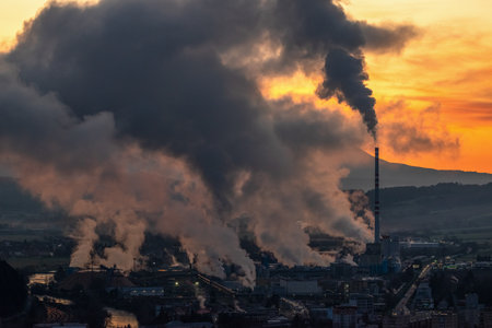 Colorful sunset over industrial city.  Air pollution from chimney. Town Ruzomberok in Sovakiaの写真素材