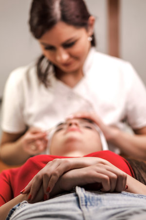 woman in spa salon getting face treatment and lying and relaxing. facial massage.の写真素材
