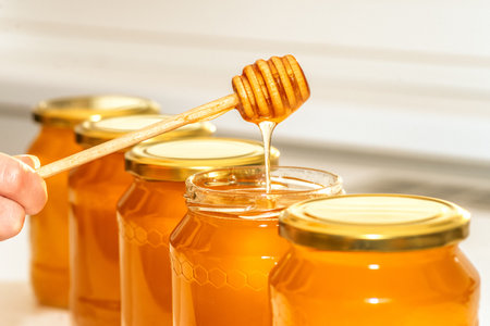 Honey in bottles. Honey dipper.