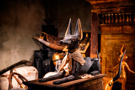 Anubis statue displayed among ancient Egyptian artifacts at a Tutankhamun exhibition, emphasizing symbolic religious meaning, detailed craftsmanship and traditional cultural expression.の写真素材