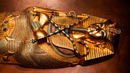 Golden pharaoh mask decorated with detailed patterns and crossed ceremonial symbols. Image represents ancient Egyptian art and craftsmanship with rich colors and historiGolden sarcophagus mask of King Tut decorated with colorful inlay patterns and crossed ceremonial symbols. The image highlights ancient Egyptian craftsmanship and royal burial art.cal aesthetics.の写真素材