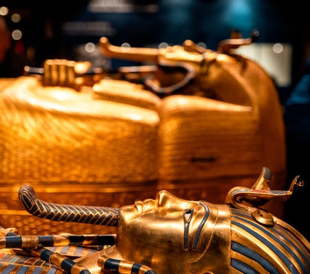 Golden mask of Tutankhamun with a cobra motif and blue inlay details showing the symbolic style of ancient Egyptian pharaohs. Warm lighting highlights the craftsmanship and decorative design.の写真素材