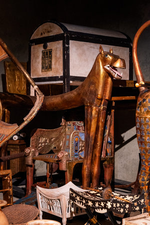 Bratislava, Slovakia - November 15, 2025: Close up view of ancient Egyptian Anubis statue with ritual burial furniture and ceremonial objects displayed at the Tutankhamun exhibition indoors.のeditorial素材