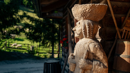 Ruzomberok, Slovakia - October 25, 2004: Hand carved wooden folk sculpture displayed at a traditional rural homestead in Cutkovska dolina, representing regional craftsmanship and cultural heritage of the Liptov region.のeditorial素材