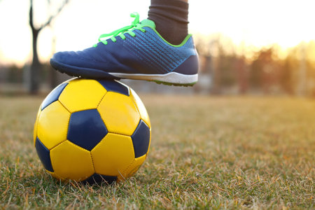 Football. A boy playing soccer on the field in the sunset.の写真素材