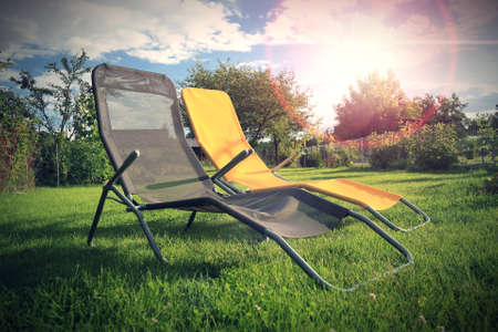 Two sun loungers standing on the grass in the garden.の写真素材