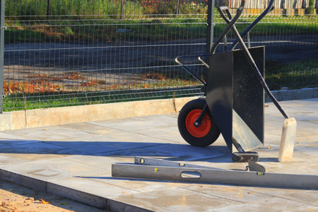 Concrete slabs. Paving tools, wheelbarrows, shovels, spirit level.