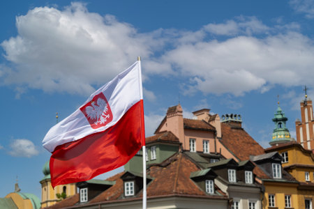 National flag of Poland waving in the wind against the background of the old town.の写真素材
