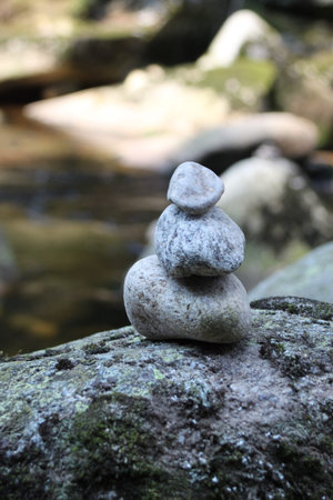 Stones stacked on top of each other by the river.