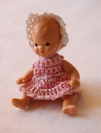 Old doll dressed in a retro pink outfit and white hat.の写真素材