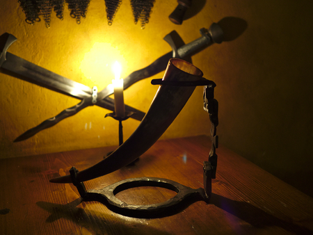 Mediaval drinking horn on the table in candle light.の写真素材