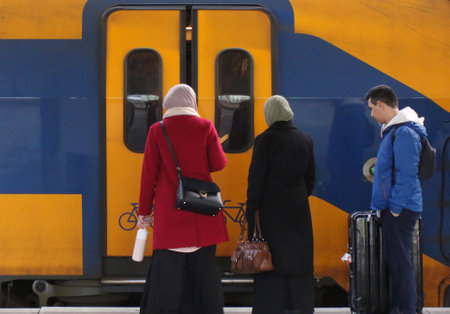 Utrecht, the Netherlands, February 15, 2019: Three people travelling with the train and waiting for the doors to open from the dutch railway system (NS)のeditorial素材