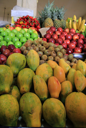 Fresh and shiny, piles of food, apple, papaya, kiwi, pepper, bananas and pineapple at a fruit marketの写真素材