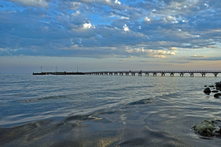 A long pier from the shore to a small marina on the calm Baltic Sea, on a cloudy afternoon. Arnager, Bornholm, Denmark.の写真素材